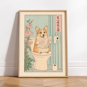 May include: Framed art print featuring a Corgi dog sitting on a toilet, reading a newspaper. The artwork has a Japanese Ukiyo-e style with a light green background, pink flowers, and a roll of toilet paper. The frame is a light wood color.