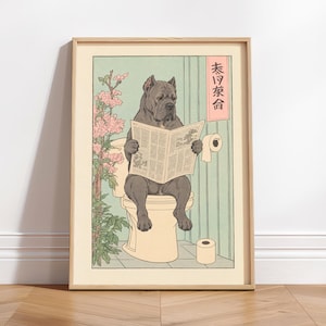 Puede incluir: Una impresión artística enmarcada que muestra a un perro gris sentado en un inodoro leyendo un periódico. La escena incluye una planta con flores rosas a la izquierda, un rollo de papel higiénico en la pared y un rollo en el suelo. Un letrero rojo vertical con texto japonés negro es visible en la pared.