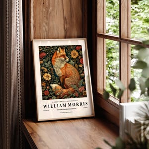 May include: A framed print featuring a fox surrounded by flowers. The print is titled "William Morris" and includes the text "Cotton Prints Exhibition, History of British Design, The Art of the 19th Century".