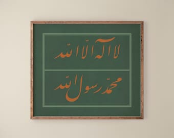May include: A framed print with a green background and a brown wooden frame. The print features two lines of Arabic calligraphy in orange, reading "La ilaha illa Allah" and "Muhammadur Rasulullah".