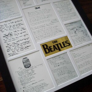 Puede incluir: Una exposici&oacute;n enmarcada de letras escritas a mano de los Beatles, incluyendo las canciones "Hey Jude", "She's Leaving Home", "Help!" y "A Day in the Life". Las letras est&aacute;n escritas en tinta negra sobre papel blanco y est&aacute;n enmarcadas en un marco blanco con un passe-partout negro.
