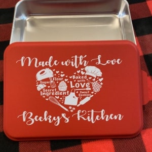 May include: Red baking pan with a white heart design and the text "Made with Love" and "Becky's Kitchen". The heart design includes illustrations of baking ingredients and tools.