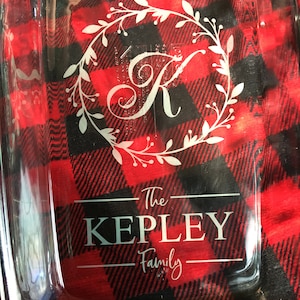 May include: A clear glass baking dish with a white design. The design includes a wreath with a letter "K" in the center, the words "The Kepley Family" and a line above and below the text.