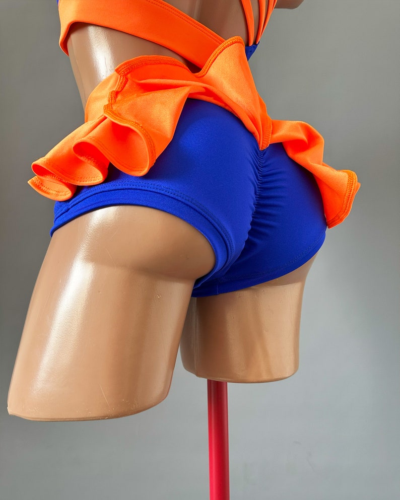 May include: A blue and orange dance costume with a ruffled skirt. The costume is made of a stretchy fabric and has a fitted bodice.