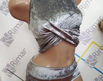 May include: A silver velvet crop top and matching shorts set. The top has a high neck and a twisted design in the front. The shorts are high-waisted and have a wide waistband.
