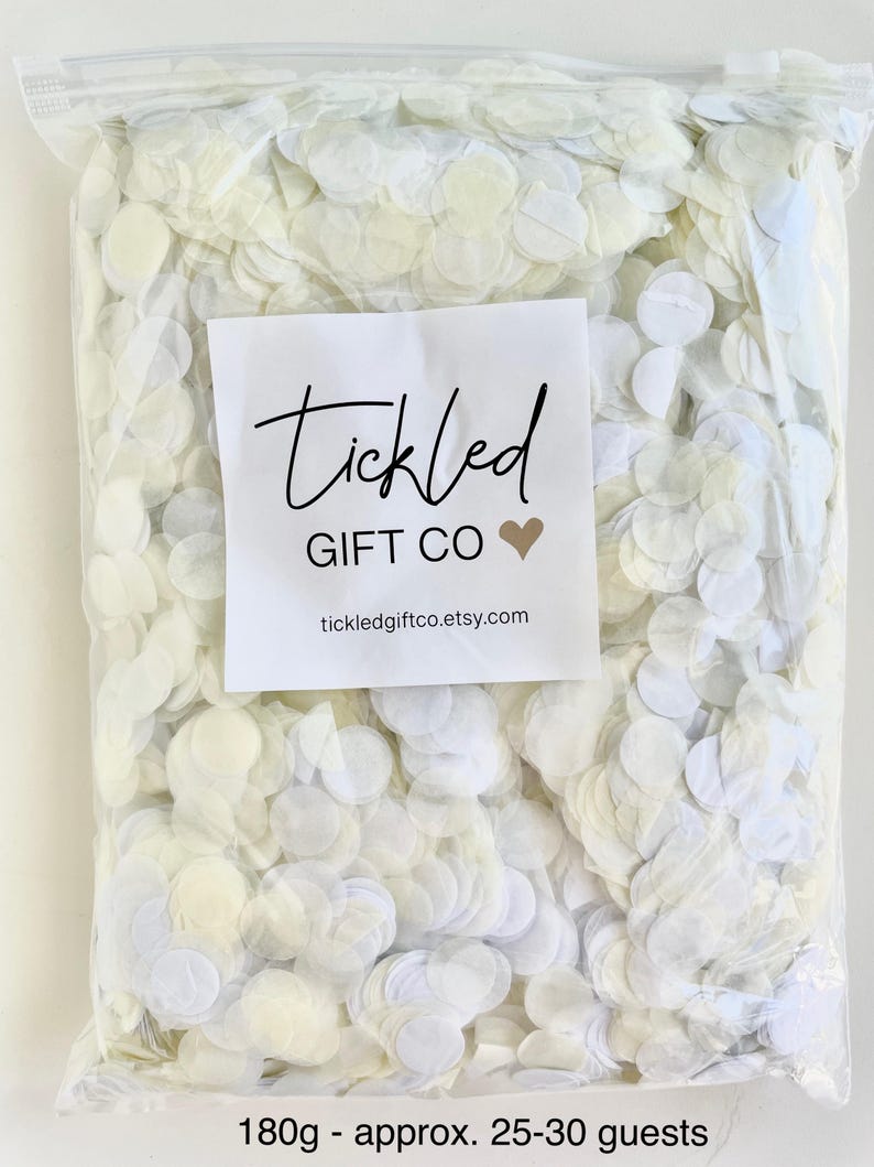 May include: A clear plastic bag filled with 180 grams of white confetti, enough for 25-30 guests. The bag has a label that says "Tickled Gift Co" and a website address.