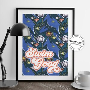 May include: A printable art print with a dark blue background and a floral pattern in shades of blue, pink, green, and yellow. The text "Swim Good" is written in a retro font in white with an orange outline.