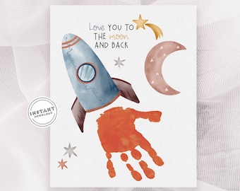 May include: A printable card with a watercolor illustration of a rocket, a crescent moon, and stars. The text "Love you to the moon and back" is written in gold lettering. A handprint is placed on the rocket.