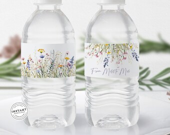 May include: Two clear plastic water bottles with labels. The label on the left bottle features a watercolour illustration of wildflowers. The label on the right bottle says "From Miss to Mrs."