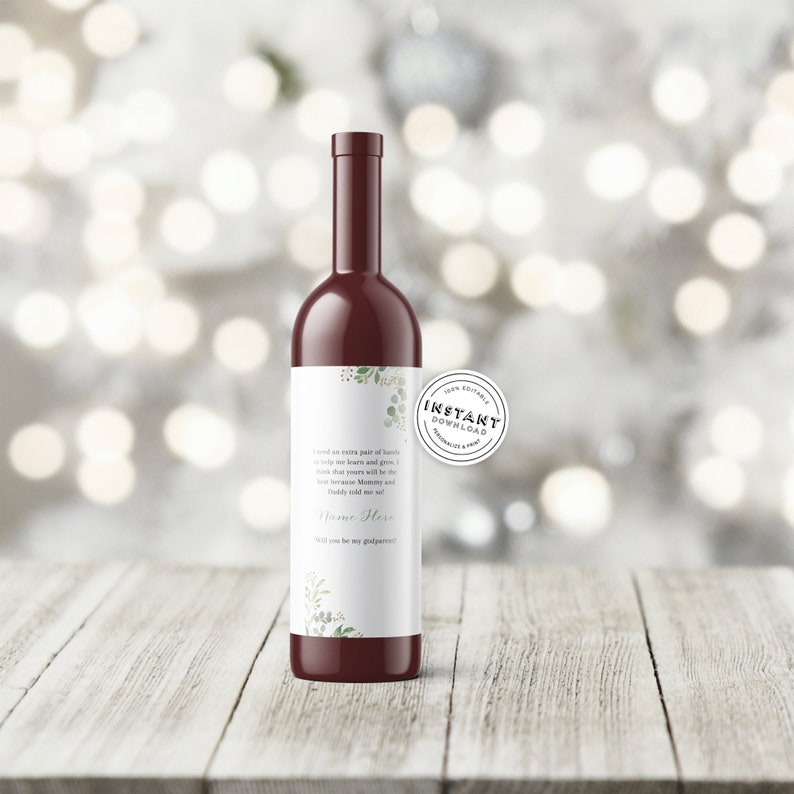 May include: A printable wine bottle label with a green floral design. The label features the text "I could an entire part of hands to help you learn and grow. I know that yours will be the work that inspires Mommy and Daddy because Mommy and Daddy told me so!" followed by "Name Here" and "You'll be my godparent".