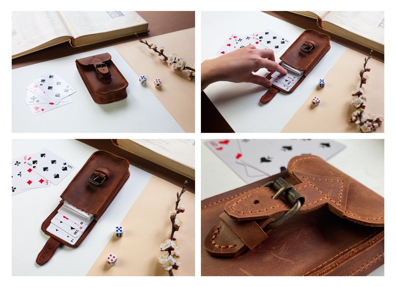 May include: A brown leather card case with a buckle closure. The case is open and a deck of playing cards is visible inside. There are also two dice on a white surface.