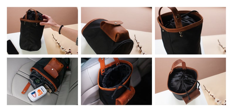 Op de afbeelding: Zwarte canvas auto-organizer met een bruin leren handvat en een klein bruin leren zakje. De organizer heeft een trekkoord sluiting en kan aan een hoofdsteun worden gehangen.