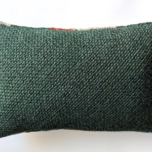 The backside of a rectangular throw pillow, in forest green colour.