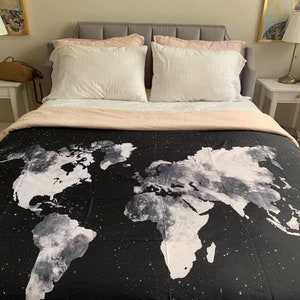 May include: A black and white world map duvet cover with a subtle star pattern. The duvet cover is on a bed with white and pink pillows.