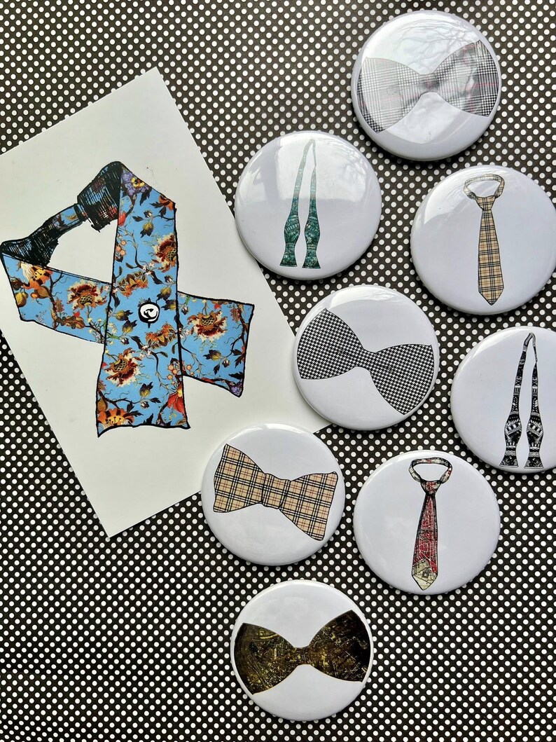 K&ouml;nnte beinhalten: Eine Auswahl wei&szlig;er Ansteckbuttons mit verschiedenen Krawatten- und Fliegen-Designs. Die Buttons zeigen Muster wie Karos, Blumen und geometrische Drucke. Eine Zeichnung einer Krawatte mit floralem Muster ist ebenfalls vorhanden.