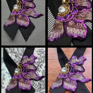 Puede incluir: Primer plano de una pajarita decorativa con una gran flor morada bordada, detalles dorados y un cristal central. La pajarita tiene una base negra y se muestra sobre varios fondos estampados.
