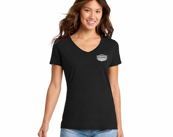May include: Black V-neck t-shirt with the text "Sandersons Garage" in a white, decorative emblem on the upper left chest. The shirt is made of a soft material and is paired with blue jeans.