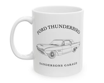 May include: White ceramic mug featuring a black line drawing of a classic Ford Thunderbird car. The text "FORD THUNDERBIRD" arches above the car, with "SANDERSONS GARAGE" below. The mug has a curved handle.