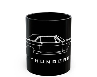 May include: Black ceramic mug featuring a white outline of a classic car. The car's design is detailed, with the word "THUNDERBIRD" printed in white along the bottom. A sleek and stylish design for car enthusiasts.