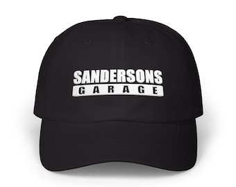 May include: Black baseball cap with the text "SANDERSONS GARAGE" in white block letters. The hat has a curved brim and a classic, adjustable design.