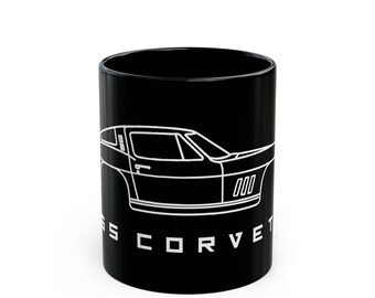 May include: Black ceramic mug featuring a white outline of a classic sports car. The mug has the text "SS CORVET" in white block letters. The design wraps around the mug, showcasing the car's profile.