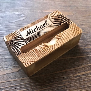 Może przedstawiać: Drewniany stojak na wizyt&oacute;wki z rzeźbionym wzorem i wygrawerowanym imieniem "Michael" z przodu.