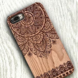 Puede incluir: Una funda de teléfono de madera con un diseño de mandala grabado con láser. La funda está hecha de madera natural y tiene un color marrón. El diseño de mandala es intrincado y detallado, y cubre toda la parte posterior de la funda.