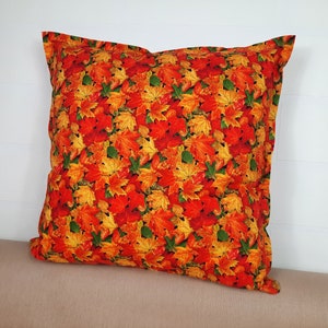 Peut inclure: Un coussin carré avec un motif d'automne. La housse de coussin présente un motif de feuilles rouges, orange, jaunes et vertes.