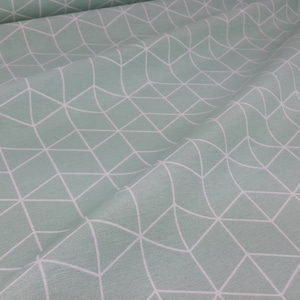 Può includere: Un tessuto verde chiaro con un motivo geometrico bianco di triangoli sovrapposti.