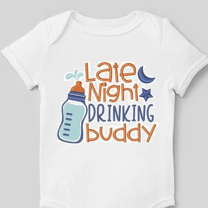以下が含まれることがあります： 青い哺乳瓶、三日月、星が描かれた白いベビーロンパース。ロンパースには「Late Night Drinking Buddy」の文字が書かれています。