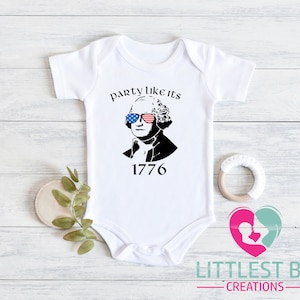May include: White baby onesie with a graphic of George Washington wearing sunglasses with a red, white, and blue American flag design. The text "party like its 1776" is above the image, and the number "1776" is below.