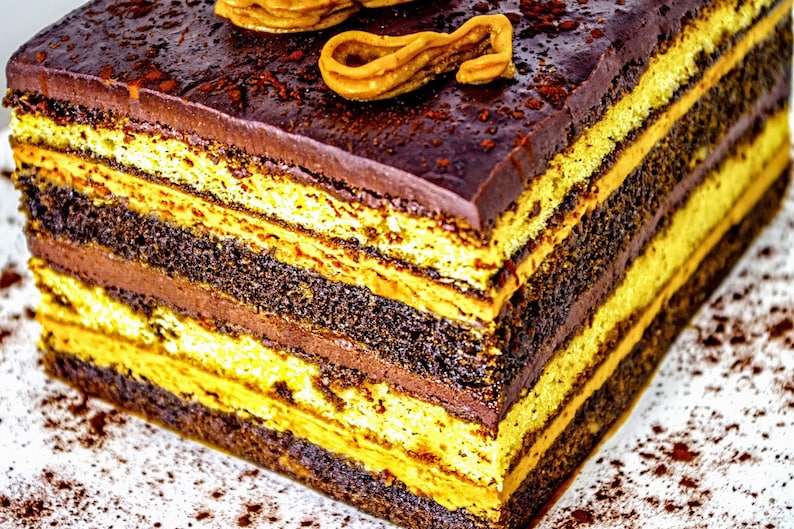 May include: A layered chocolate cake with alternating layers of chocolate and yellow cake, topped with chocolate frosting and a swirl of caramel.