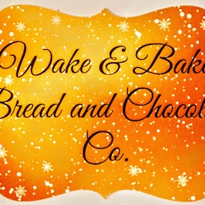 May include: A gold and orange sign with a white snowflake pattern. The sign reads "Wake & Bake Bread and Chocolate Co."