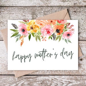 May include: A white card with a watercolor floral design in shades of pink, orange, and yellow. The text "happy mother's day" is written in black cursive.