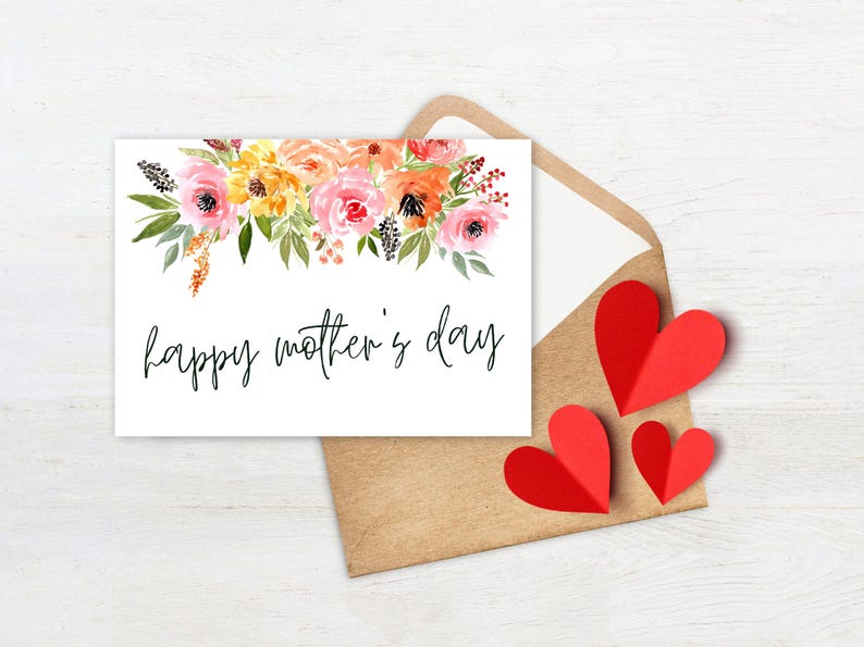 May include: A white card with a watercolor floral border and the text "happy mother's day" in black script. The card is sitting on a brown envelope with three red paper hearts.