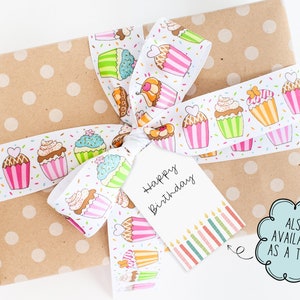 May include: A wrapped gift with a polka-dot brown paper and a white ribbon decorated with colorful cupcakes. A white tag with "Happy Birthday" is attached to the ribbon. The tag also has a row of colorful candles.