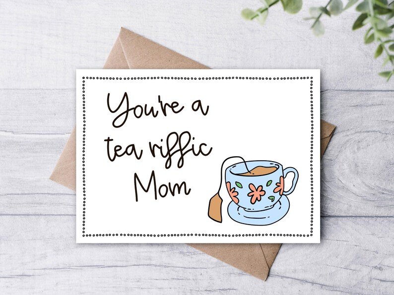 May include: A white card with black text that reads "You're a tea riffic Mom" and a cartoon illustration of a blue teacup with a tea bag.