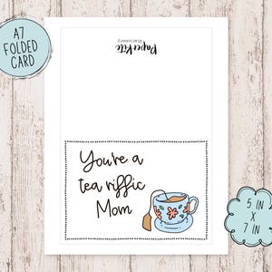 May include: A folded greeting card with a black and white border. The card has a teacup with flowers and the text "You're a tea riffic Mom" on a white background.