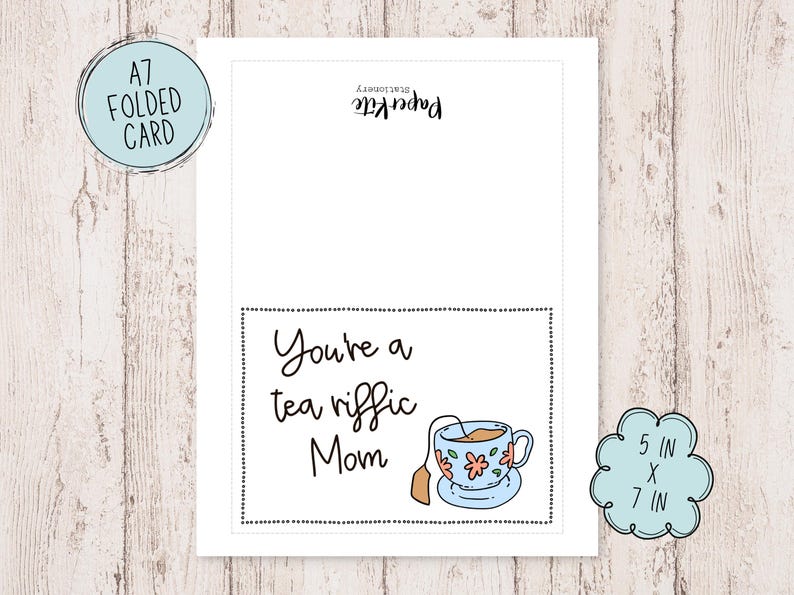 May include: A folded greeting card with a black and white border. The card has a teacup with flowers and the text "You're a tea riffic Mom" on a white background.