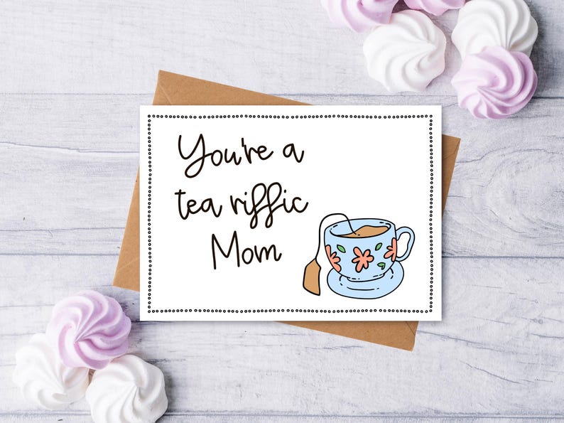 May include: A white card with black text that reads "You're a tea riffic Mom" and a cartoon illustration of a blue teacup with pink flowers and a tea bag.