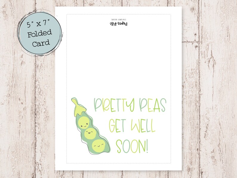 May include: A folded card, 5" x 7", with a light blue border. The card features a green pea pod illustration with smiling faces and the text "PRETTY PEAS GET WELL SOON!" in green. The card is on a light wood grain surface.