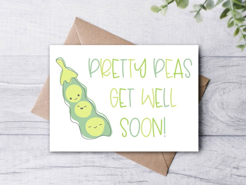 May include: A white greeting card with the text "Pretty Peas Get Well Soon!" in green and light green. The card features a cartoon pea pod with three smiling peas. The card is on a brown envelope.