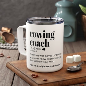 May include: White travel mug with a black design that says "rowing coach" and a definition of the word. The definition says "Someone who solves problems you never knew existed in ways that will blow your mind. See also: ninja; badass; legend"