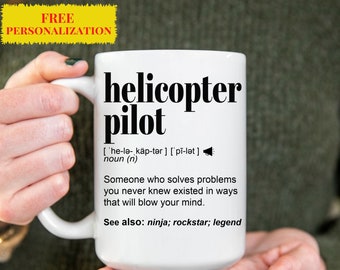 May include: White ceramic mug with a black design that reads "helicopter pilot" and defines the term as "Someone who solves problems you never knew existed in ways that will blow your mind." The mug also includes the text "See also: ninja; rockstar; legend".