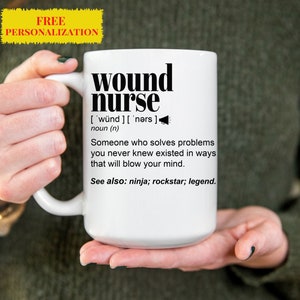 May include: White ceramic mug with a black graphic that reads "wound nurse" and defines the term as "someone who solves problems you never knew existed in ways that will blow your mind." The graphic also includes the text "See also: ninja; rockstar; legend."