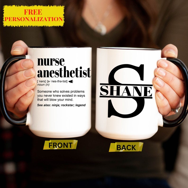 May include: White ceramic coffee mug with a black rim and handle. The front of the mug has the definition of "nurse anesthetist" printed in black. The back of the mug has a black letter "S" with the name "SHANE" printed across the middle.