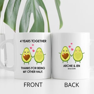 Puede incluir: Taza de cer&aacute;mica blanca con un gr&aacute;fico de dos mitades de aguacate que se toman de la mano con corazones en el medio. El texto en la parte delantera dice "4 Years Together Thanks for Being My Other Half." El texto en la parte posterior dice "Archie & Jen since 2015."