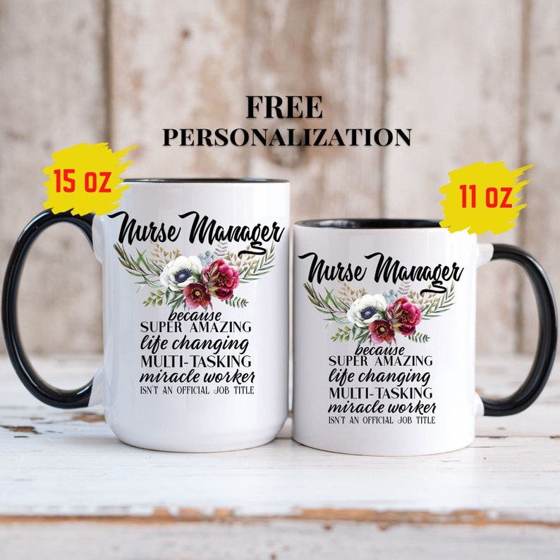 May include: Two white ceramic mugs with black handles and black rims. The mugs have a floral design and the text "Nurse Manager because SUPER AMAZING life changing MULTI-TASKING miracle worker ISN'T AN OFFICIAL JOB TITLE". The mugs are available in 11 oz and 15 oz sizes.
