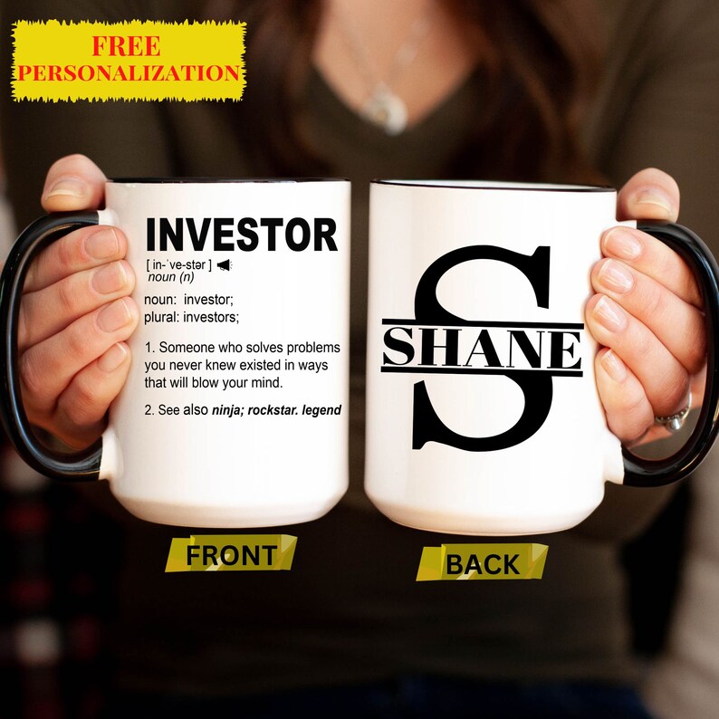 May include: White ceramic mug with a black handle and rim. The front of the mug has the word "INVESTOR" defined as "Someone who solves problems you never knew existed in ways that will blow your mind." The back of the mug has a black letter "S" with the name "SHANE" written across the middle.