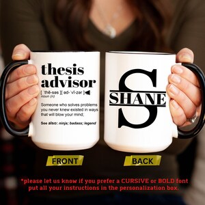 May include: White ceramic mug with black handle and rim. The front of the mug reads "thesis advisor" with a definition. The back of the mug has a large letter "S" with the name "SHANE" inside. The mug is held by a person.